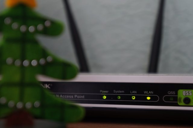 Laptop neben einem WLAN-Router – Symbolbild für WLAN-Verwaltung in Windows