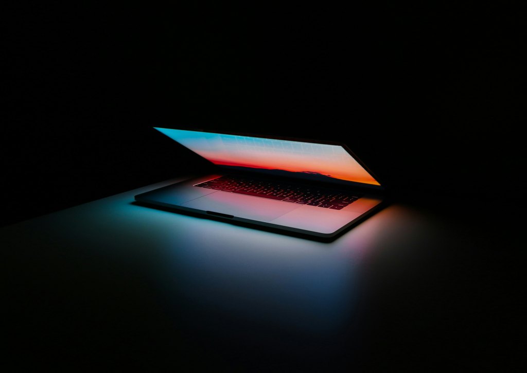 Entwicklungsarbeitsplatz mit Laptop in dunkler technischer Umgebung als Symbolbild für KI-gestützte Coding-Workflows über Ollama